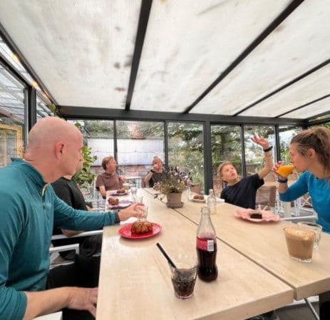 Runners at a café table with coffee and cake after the run